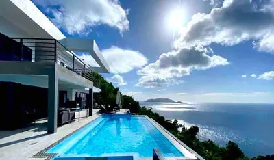 a house with a swimming pool overlooking the ocean at Villa Modere' in Tortola Island