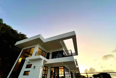 a large white house with a sunset in the background at Villa Modere' in Tortola Island