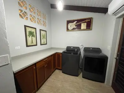 a kitchen with a stove and a trash can at Tamarind Villa in Virgin Gorda