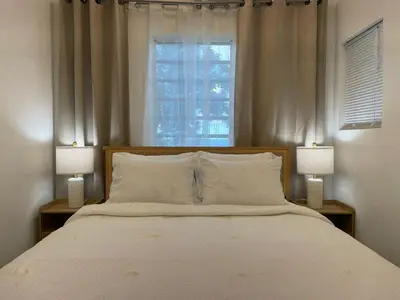a bedroom with a large bed with two lamps at Abigail's Sunlit Nook in Tortola Island