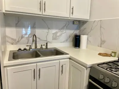 a white kitchen with a sink and a stove at Abigail's Sunlit Nook in Tortola Island