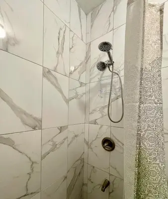 a bathroom with a shower with marble tiles at Abigail's Sunlit Nook in Tortola Island