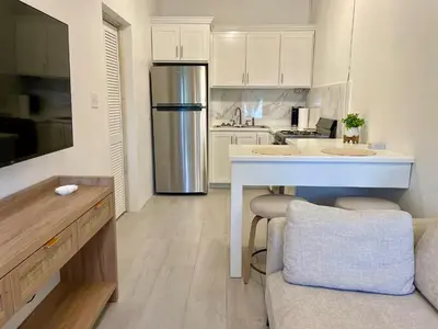a kitchen with a refrigerator and a table in it at Abigail's Sunlit Nook in Tortola Island