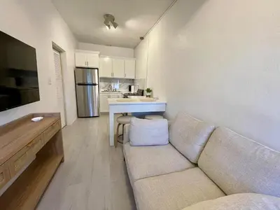 a living room with a couch and a kitchen at Abigail's Sunlit Nook in Tortola Island