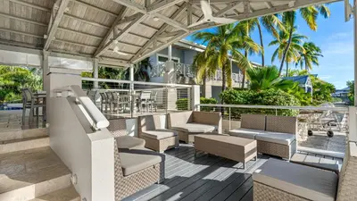 a patio with chairs and tables and palm trees at Moorings Yacht Club in Road Town