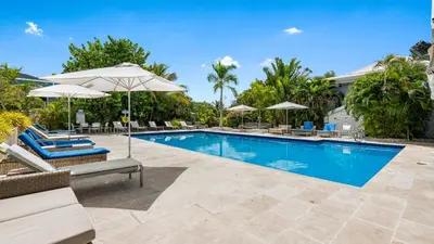 a swimming pool with lounge chairs and umbrellas at Moorings Yacht Club in Road Town