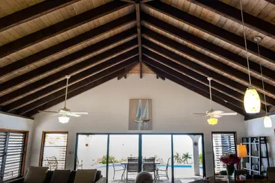 a living room with vaulted ceilings and a pool at Villa ValMarc Mahoe Bay Virgin Gorda BVI in Virgin Gorda