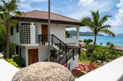 a house with a staircase leading to the ocean at Villa ValMarc Mahoe Bay Virgin Gorda BVI in Virgin Gorda