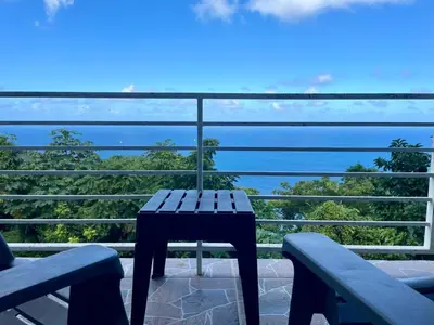 a table on a balcony with a view of the ocean at Abigail's Esmeralda 2 bedrom Apt in Tortola Island