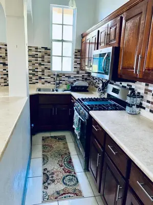 a kitchen with wooden cabinets and a stove top oven at Tranquil Escape at Ballast Bay in Road Town