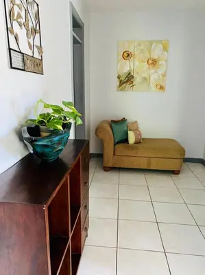 a living room with a couch and a plant on a dresser at Tranquil Escape at Ballast Bay in Road Town