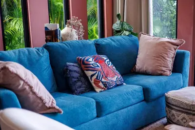 a blue couch with pillows on it in a living room at Odyssea Oasis in Tortola Island