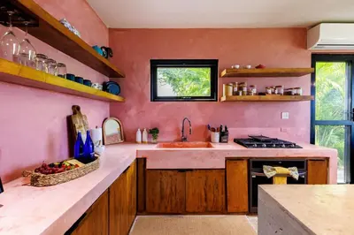 a kitchen with pink walls and a sink and a counter at Odyssea Oasis in Tortola Island