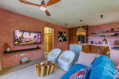 a living room with a blue couch and a kitchen at Odyssea Oasis in Tortola Island