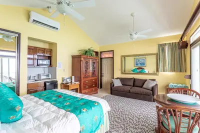 a bedroom with a bed and a couch at Sebastian's on the beach hotel in Road Town