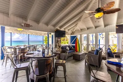 a restaurant with tables and chairs and a view of the ocean at Sebastian's on the beach hotel in Road Town