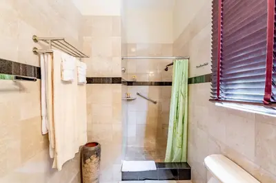 a bathroom with a shower with a shower curtain at Sebastian's on the beach hotel in Road Town