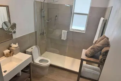 a bathroom with a shower and a toilet and a sink at Wyndham Tortola BVI Lambert Beach Resort in East End