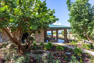 a pavilion in a garden with trees at Wyndham Tortola BVI Lambert Beach Resort in East End