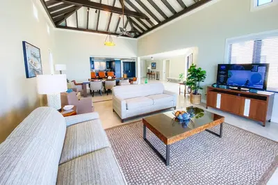 a living room with a couch and a table at Scrub Island Resort, Spa & Marina in The Mill