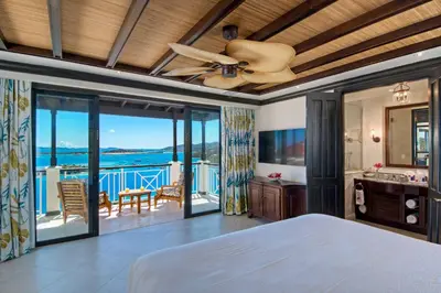 a bedroom with a bed and a ceiling fan at Scrub Island Resort, Spa & Marina in The Mill