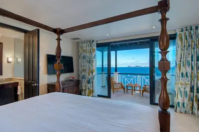 a bedroom with a bed and a view of the ocean at Scrub Island Resort, Spa & Marina in The Mill