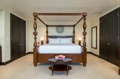 a bedroom with a bed and a table with flowers on it at Scrub Island Resort, Spa & Marina in The Mill