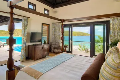 a bedroom with a bed and a view of the ocean at Scrub Island Resort, Spa & Marina in The Mill