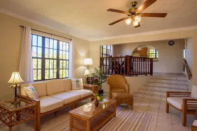 a living room with a couch and a ceiling fan at Bayview Vacation Apartments in Virgin Gorda