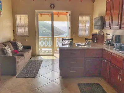 a kitchen and living room with a couch and a table at Ocean View Villas in Jost Van Dyke
