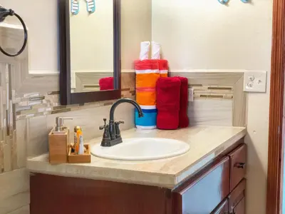 a bathroom counter with a sink and a mirror at Ocean View Villas in Jost Van Dyke