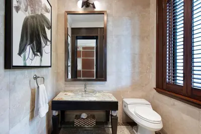 a bathroom with a toilet and a sink and a mirror at Peter Island Resort in Anderson