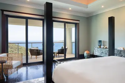 a bedroom with a bed and a view of the ocean at Peter Island Resort in Anderson