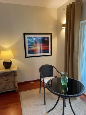 a living room with a table and a chair at Sugar Mill Hotel in Great Carrot Bay