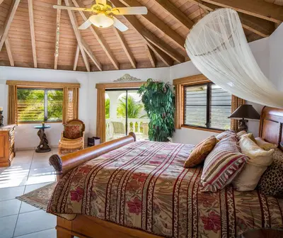 a bedroom with a large bed with a ceiling at TAMAR VILLA in Virgin Gorda