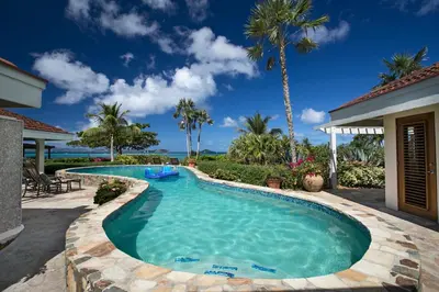 a swimming pool in the backyard of a house at BEACHCOMBER VILLA in Virgin Gorda