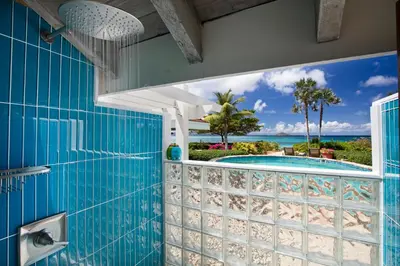 a bathroom with a view of a swimming pool at BEACHCOMBER VILLA in Virgin Gorda