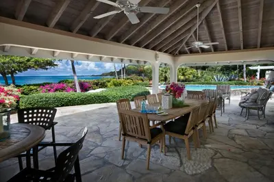 a patio with a table and chairs and a pool at BEACHCOMBER VILLA in Virgin Gorda