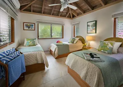 a bedroom with two beds and a ceiling fan at BEACHCOMBER VILLA in Virgin Gorda