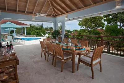 a patio with a table and chairs and a pool at BLUE LAGOON in Virgin Gorda