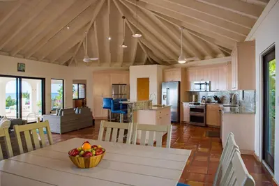 a kitchen with a table with a bowl of fruit on it at BEACH DREAMS in Virgin Gorda