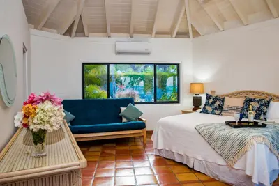 a bedroom with a bed and a blue couch at BEACH DREAMS in Virgin Gorda