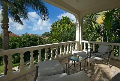 a porch with a table and chairs on a balcony at BELLAMARE in Virgin Gorda
