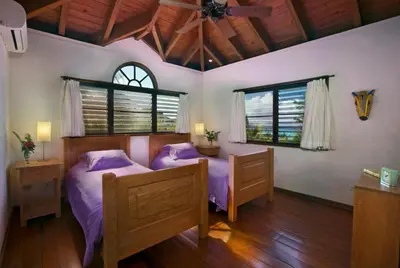a bedroom with two beds and two windows at BELLAMARE in Virgin Gorda
