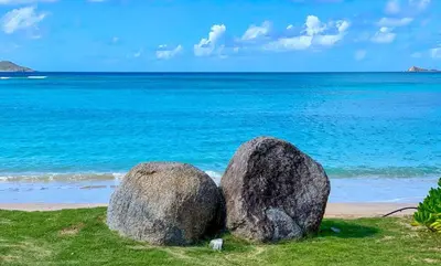 two large rocks sitting on a beach near the ocean at CARIBBEAN WIND in Virgin Gorda