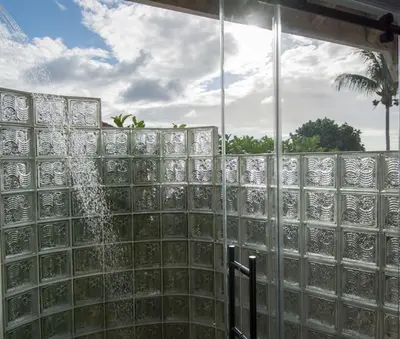 a shower with glass tiles on a wall at SANDCASTLE in Virgin Gorda