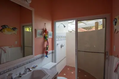 a bathroom with a shower and a sink and a mirror at SANDCASTLE in Virgin Gorda