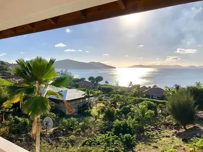 a view of the ocean from a resort with a palm tree at VILLA VALMARC in Virgin Gorda