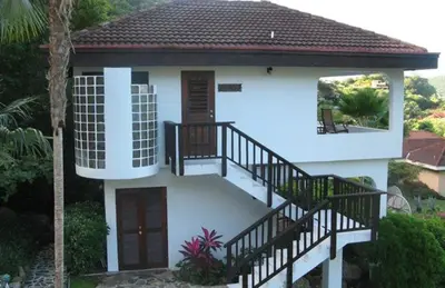 a small house with a staircase and a balcony at VILLA VALMARC in Virgin Gorda