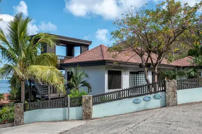 a house with a fence in front of it at VILLA DEL SOLE in Virgin Gorda